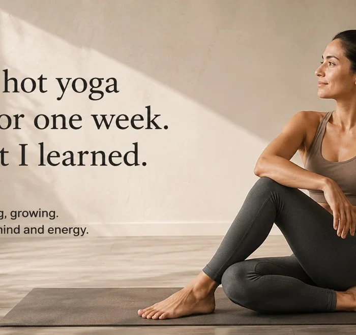 Woman sitting on a yoga mat after completing a seven-day hot yoga challenge in a calm yoga studio.